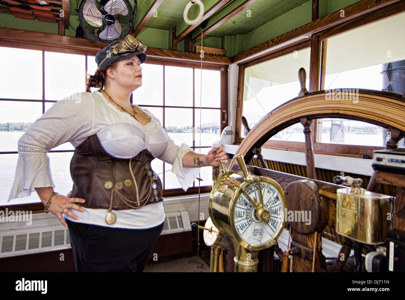 Giovane Donna vestita di steampunk in posa nella timoneria su Belle of Louisville Foto Stock