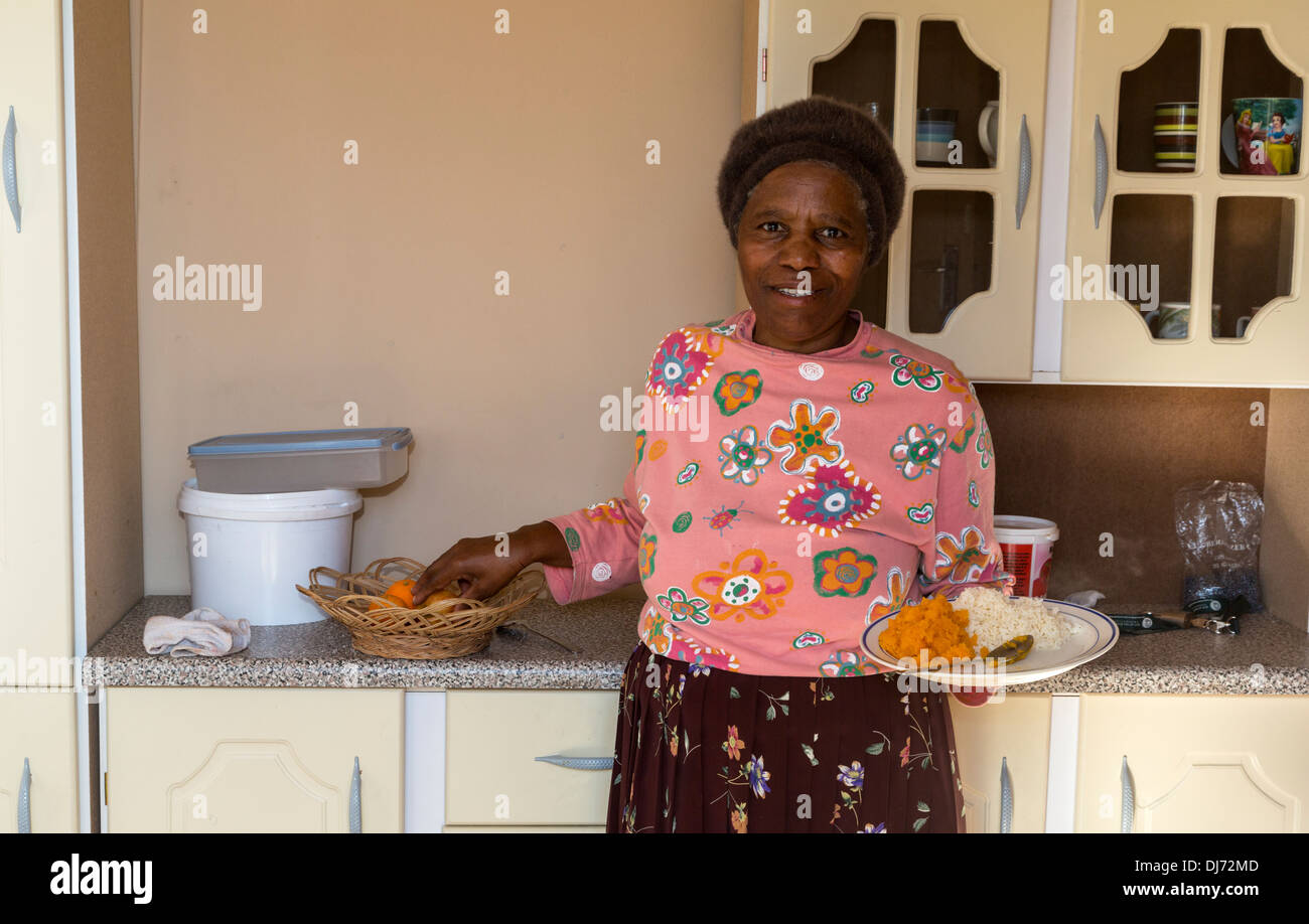 Sud Africa, Cape Town, Khayelitsha Township. Donna con pranzo in lei una stanza di casa. Foto Stock