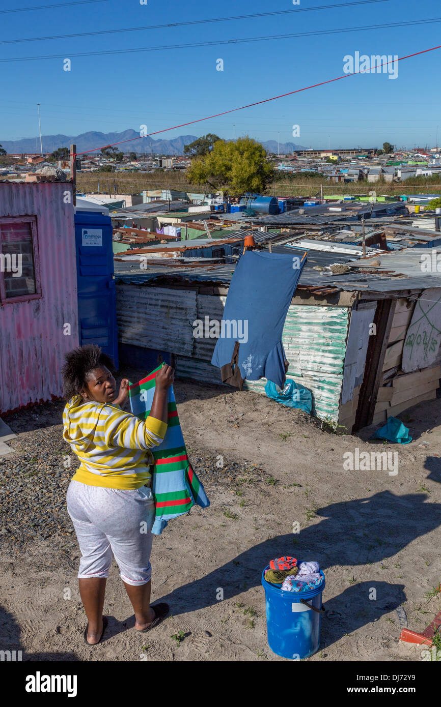 Sud Africa, Cape Town, Khayelitsha Township. Donna appeso il suo servizio lavanderia. Foto Stock