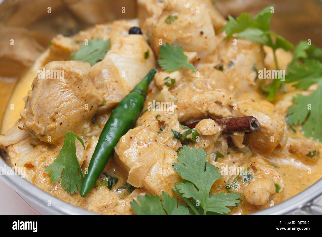 Vista ravvicinata di Balti chicken pasanda curry serviti, guarnite con foglie di coriandolo e un peperoncino rosso in e indiana servin kadai Foto Stock