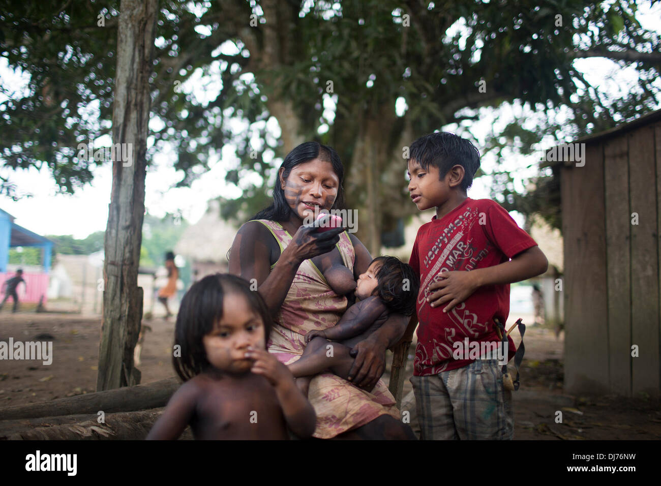 Apr 22, 2013 - Poti-Kro, Para, Brasile - Una madre Xikrin ascolta la musica come lei breastfeeds sua figlia. Xikrin persone vivono sul Bacaja, un affluente del fiume Xingu, dove la costruzione di Belo Monte Dam raggiungendo il picco di costruzione. Alcuni scienziati avvertono che il livello di acqua dell'Bacaja diminuiscono precipitosamente a causa della diga. (Credito Immagine: © Taylor Weidman/ZUMA filo/ZUMAPRESS.com) Foto Stock