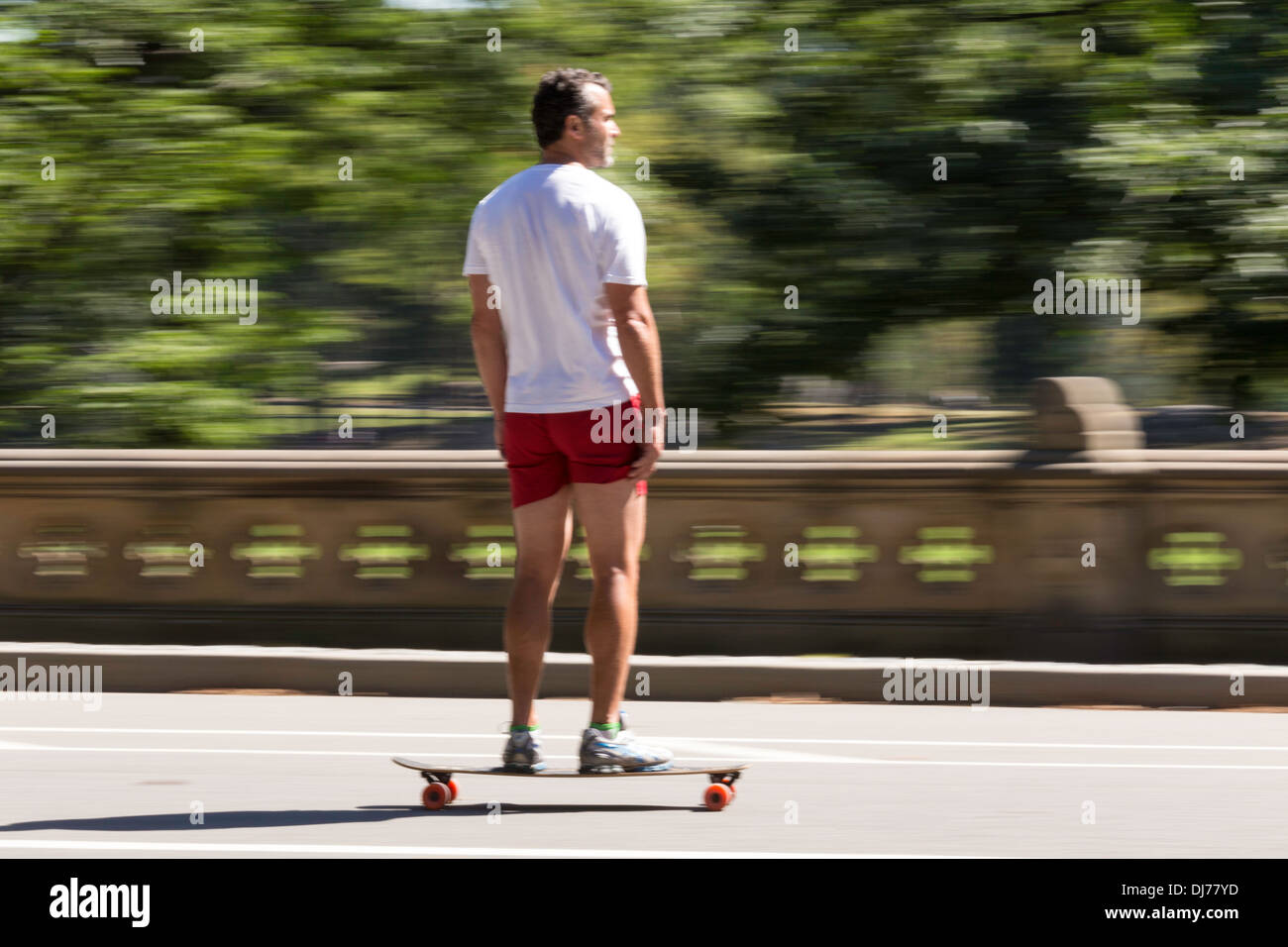 L'uomo coste sul suo skateboard in Central Park, NYC Foto Stock