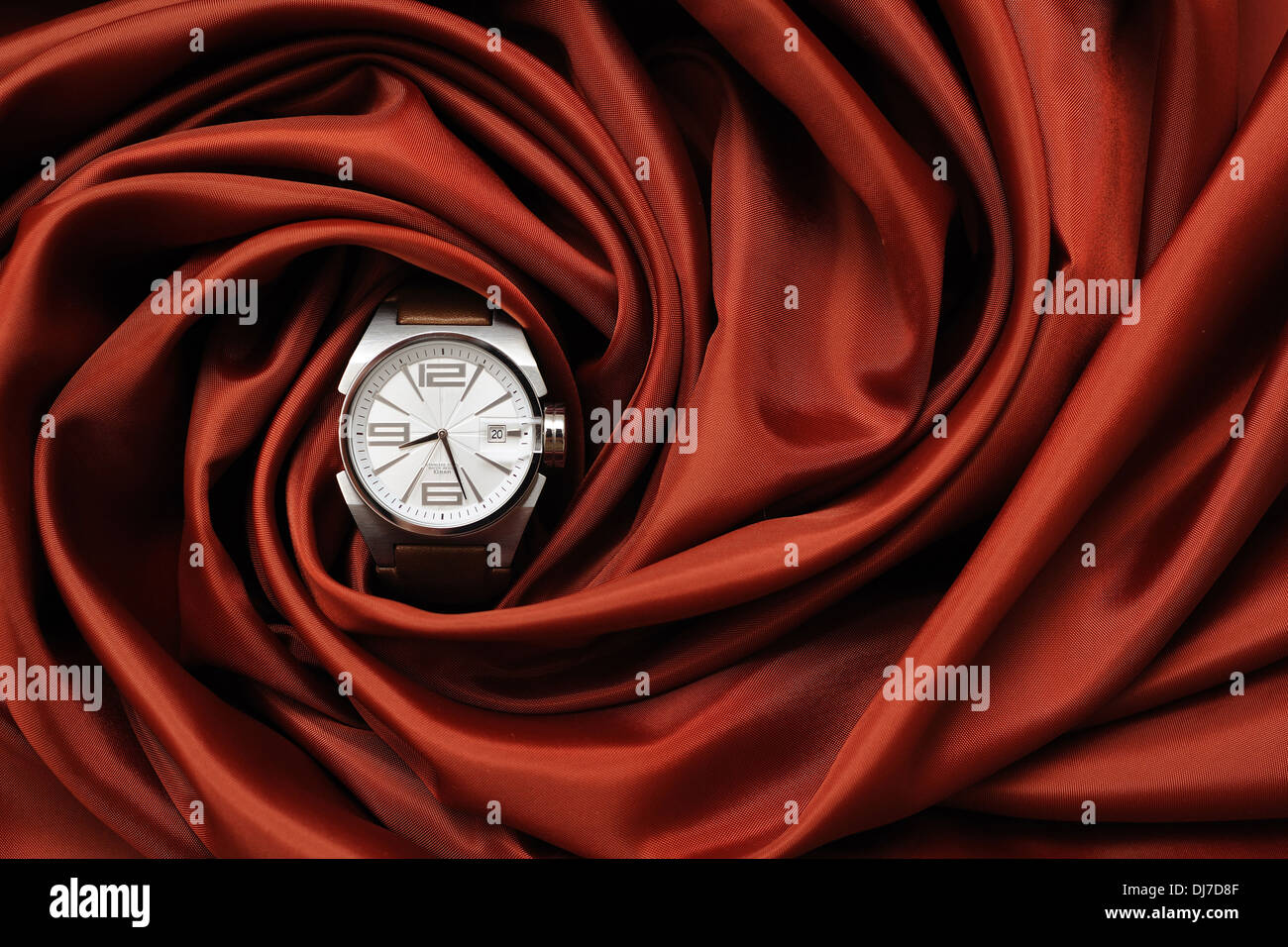 Un orologio da polso su un panno rosso Foto Stock