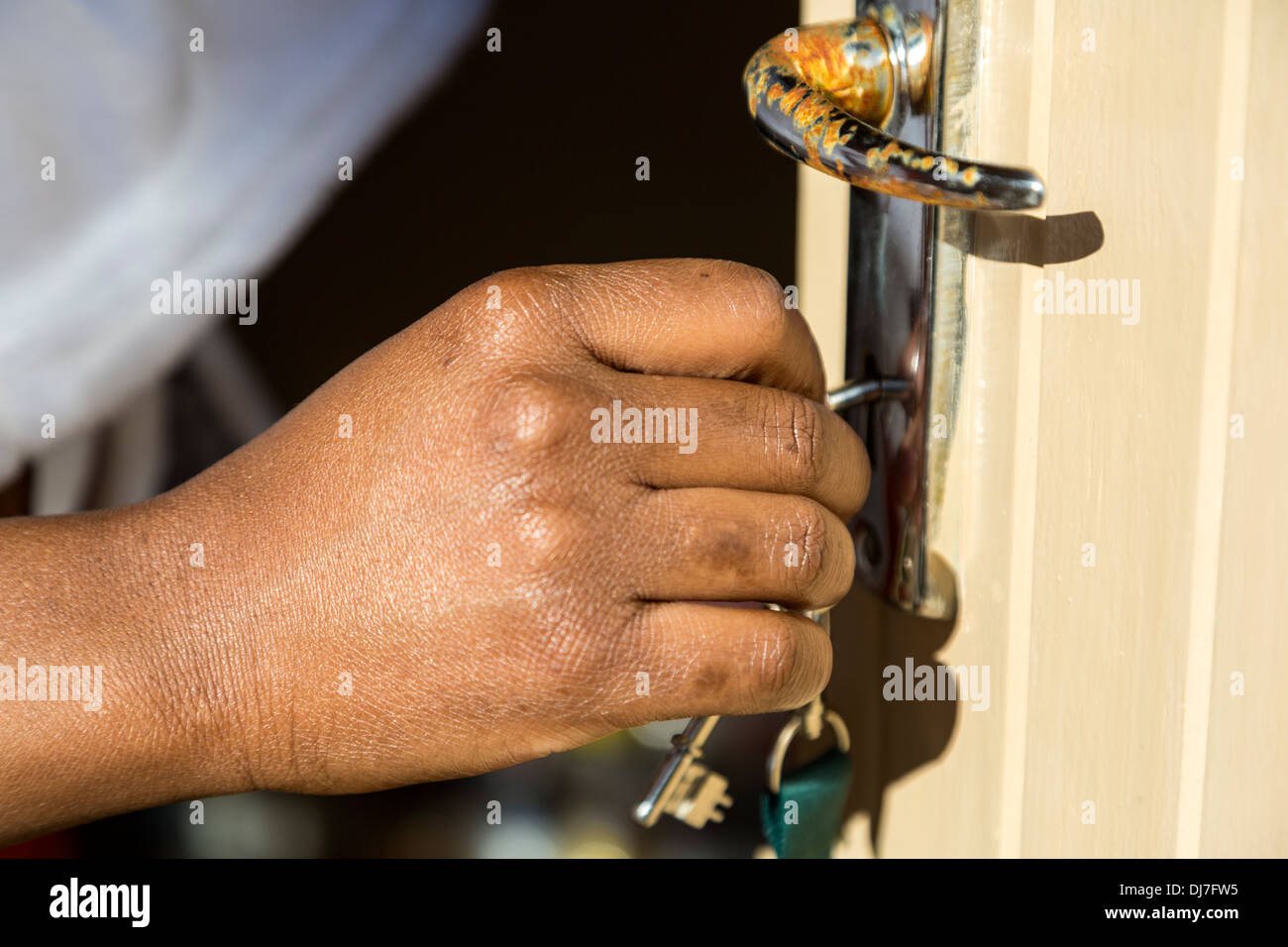 Sud Africa, Cape Town, Khayelitsha Township alloggiamento. Nuovo proprietario cerca la chiave nella porta per la prima volta. Foto Stock