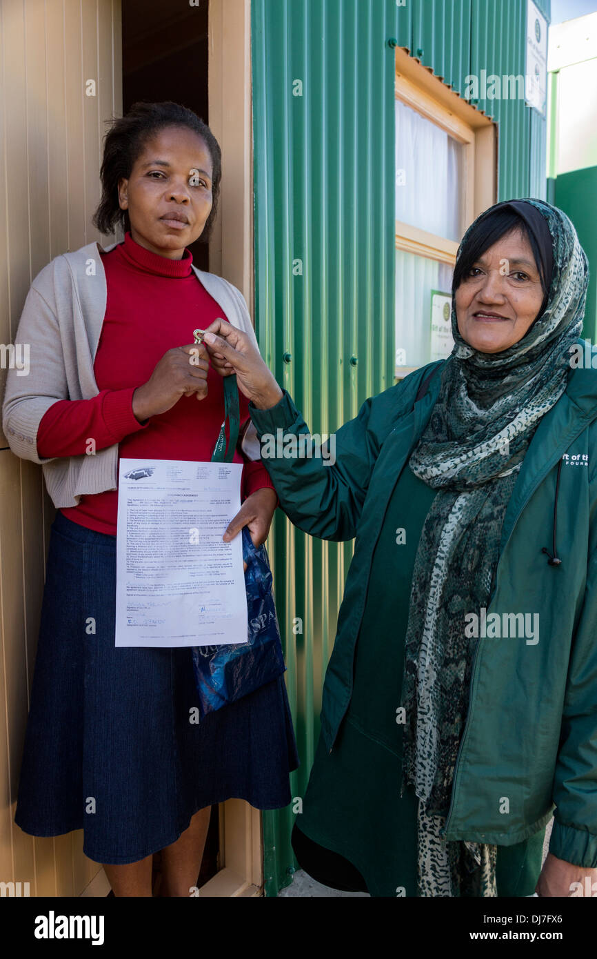 Sud Africa, Cape Town, Khayelitsha Township alloggiamento. Donna chiave di ricezione alla nuova casa finanziato dal dono della o un infermiere, una carità. Foto Stock