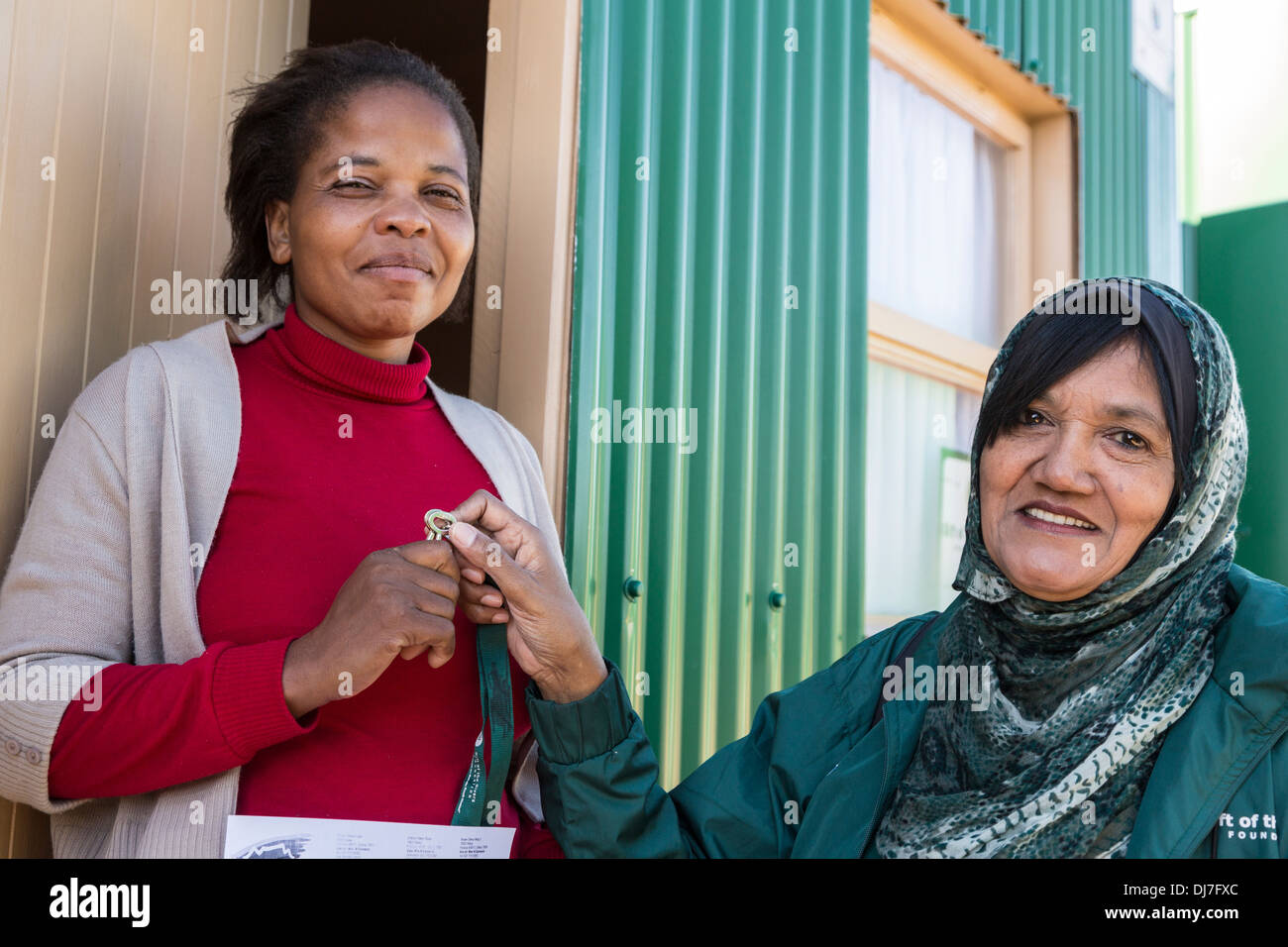 Sud Africa, Cape Town, Khayelitsha Township alloggiamento. Donna chiave di ricezione alla nuova casa finanziato dal dono della o un infermiere, una carità. Foto Stock