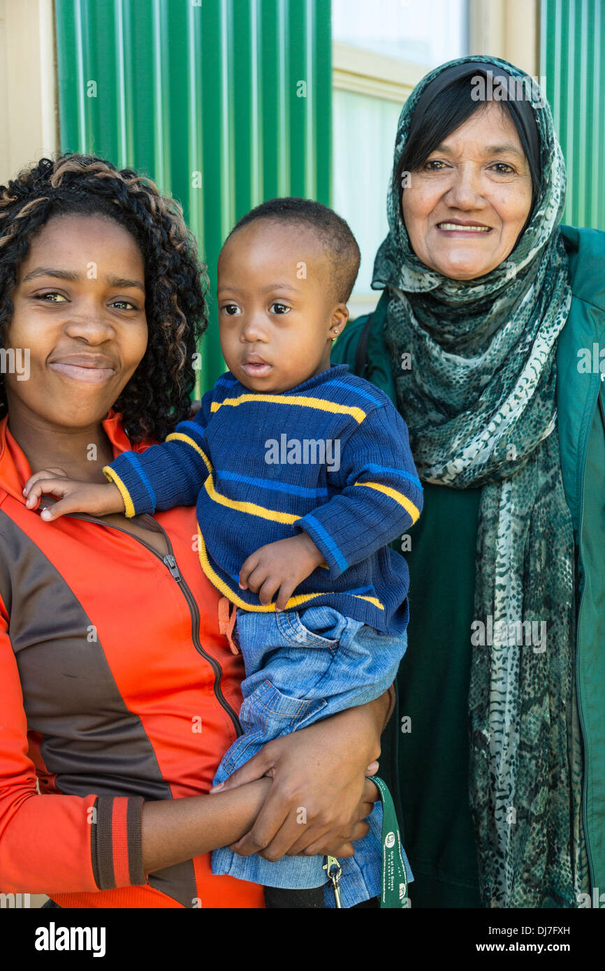 Sud Africa, Cape Town, Khayelitsha Township alloggiamento. Donna e giovane figlio circa per entrare in casa di nuova costruzione finanziato dal dono della ai malati Foto Stock