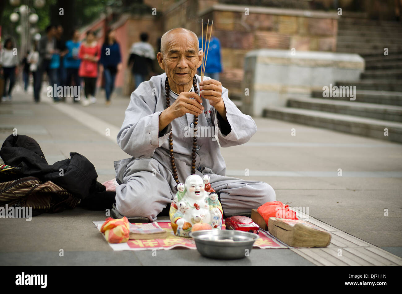 Devoto buddista mendicando per la parte anteriore del tempio Zumiao ,Foshan ,Cina Foto Stock