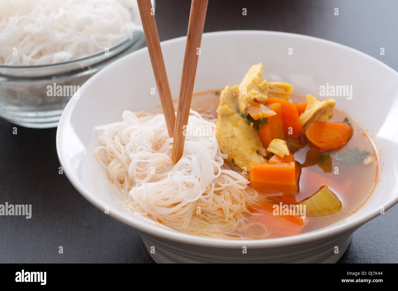 Brodo di pollo minestra con la carota, la cipolla, il sedano e il pollo. Servito con riso tagliatelle. Foto Stock
