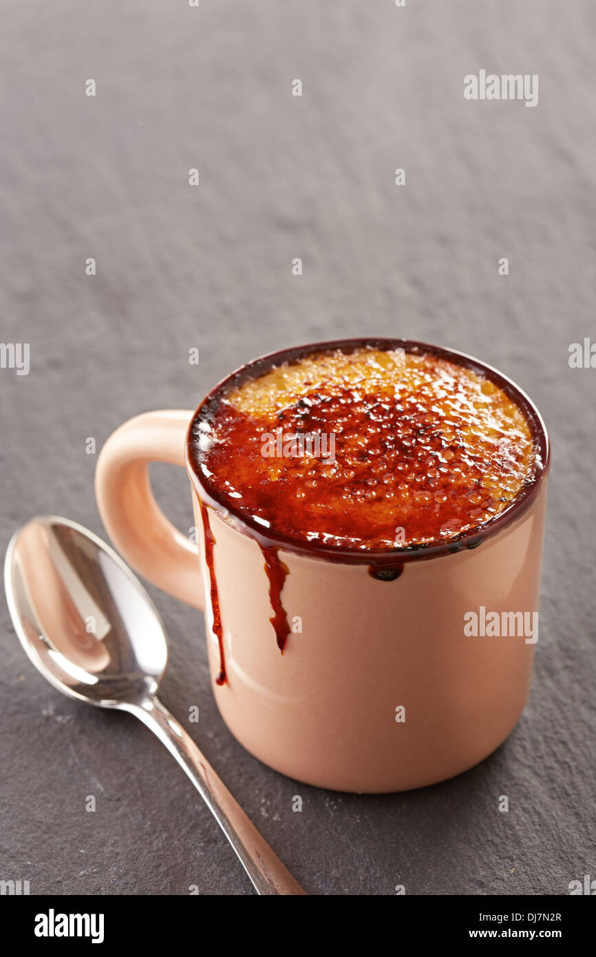 Creme brulee in una tazza su una scheda di ardesia Foto Stock