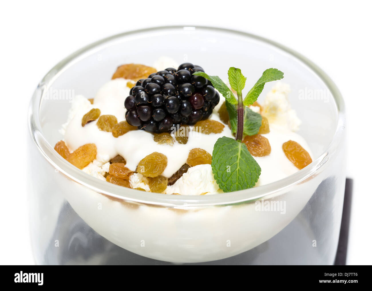 Formaggio con panna acida e uva passa su sfondo bianco Foto Stock