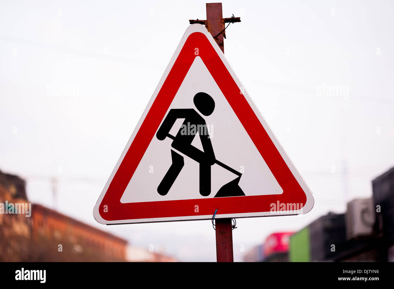 Rosso e nero sotto il segno di costruzione con lo scavo di uomo della strada. Foto Stock