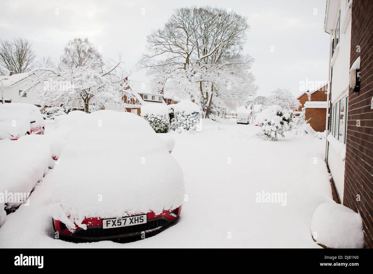 Un auto coperto di neve profonda, parcheggiata sul vialetto di una casa Foto Stock