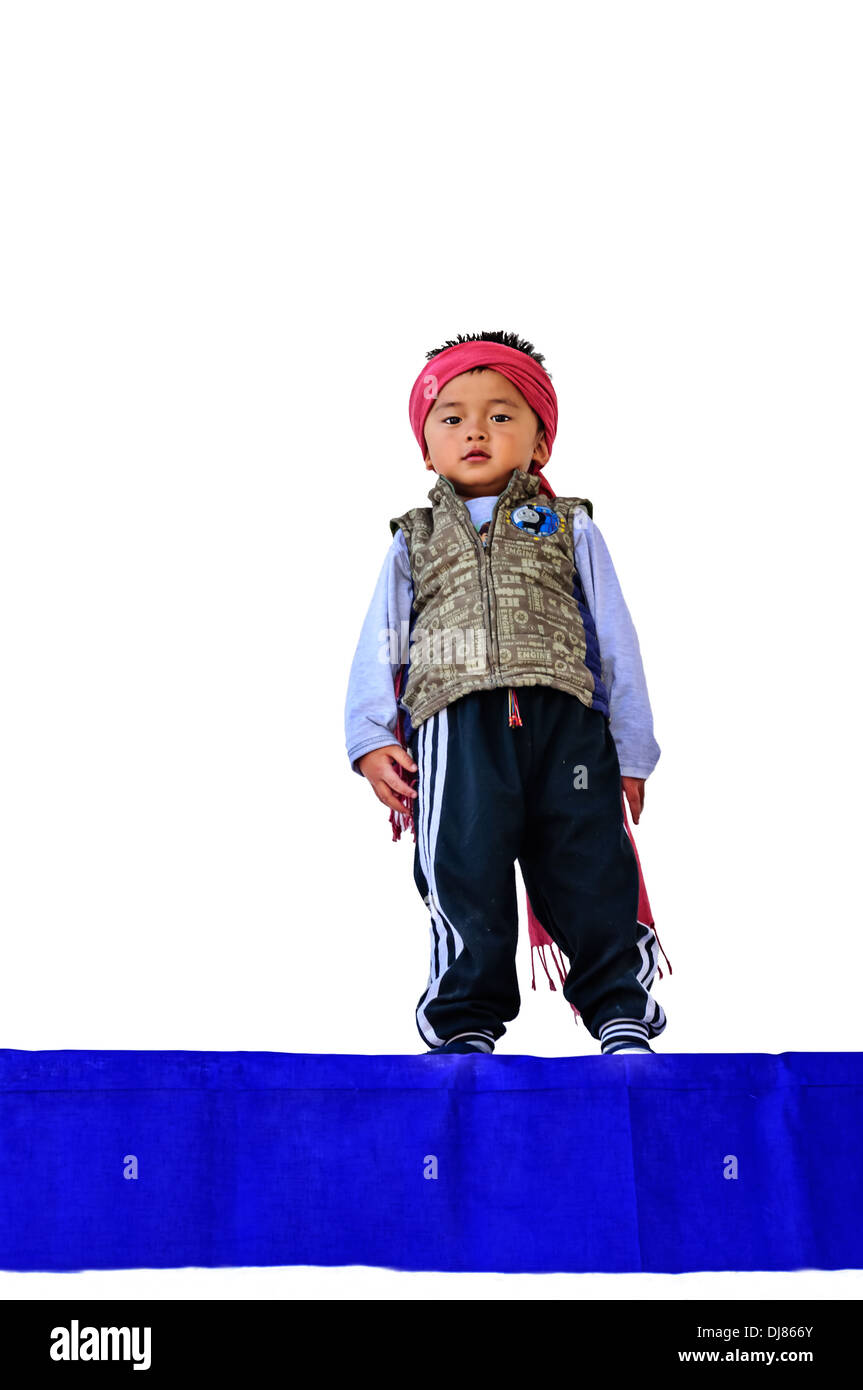Little Boy bhutanesi giocando contro il muro bianco Foto Stock