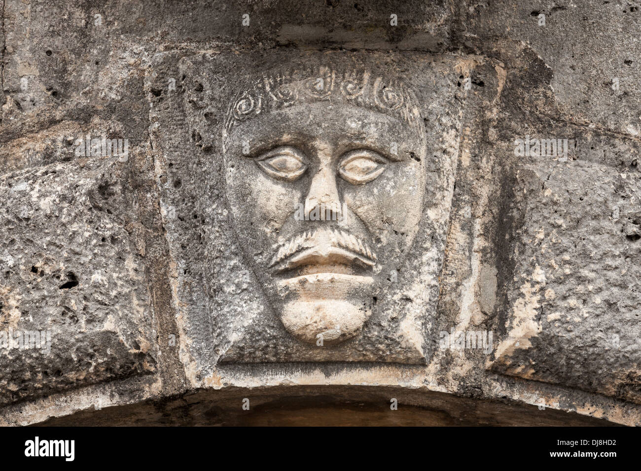 Bassorilievo con il volto dell'uomo sulla casa antica facciata in città Perast, Montenegro Foto Stock
