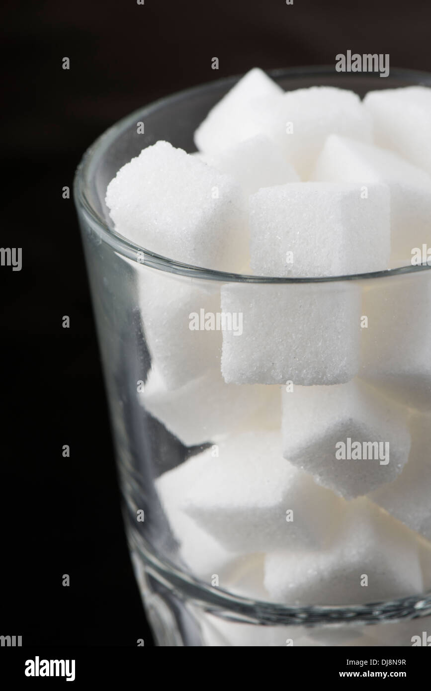 Close up di un bicchiere riempito con cubetti di zucchero Foto Stock