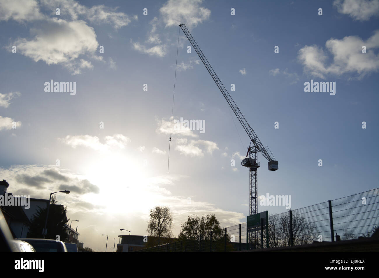 Grande gru sul sito in costruzione a Londra, con il sole che tramonta in distanza. Foto Stock