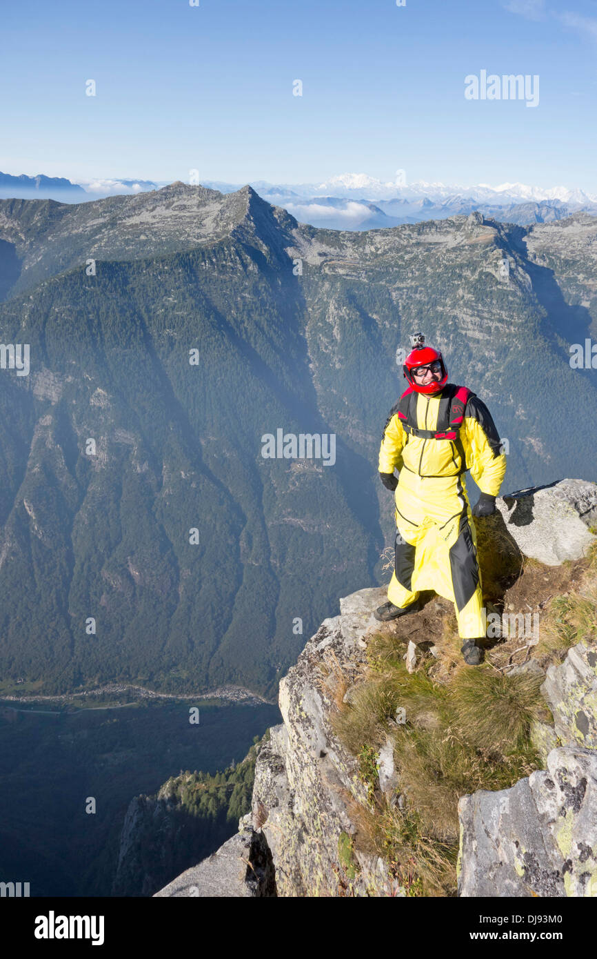 Base Wingsuit ponticello si prepara a saltare da una scogliera nella profonda valle e ha un aspetto molto nervoso. Foto Stock