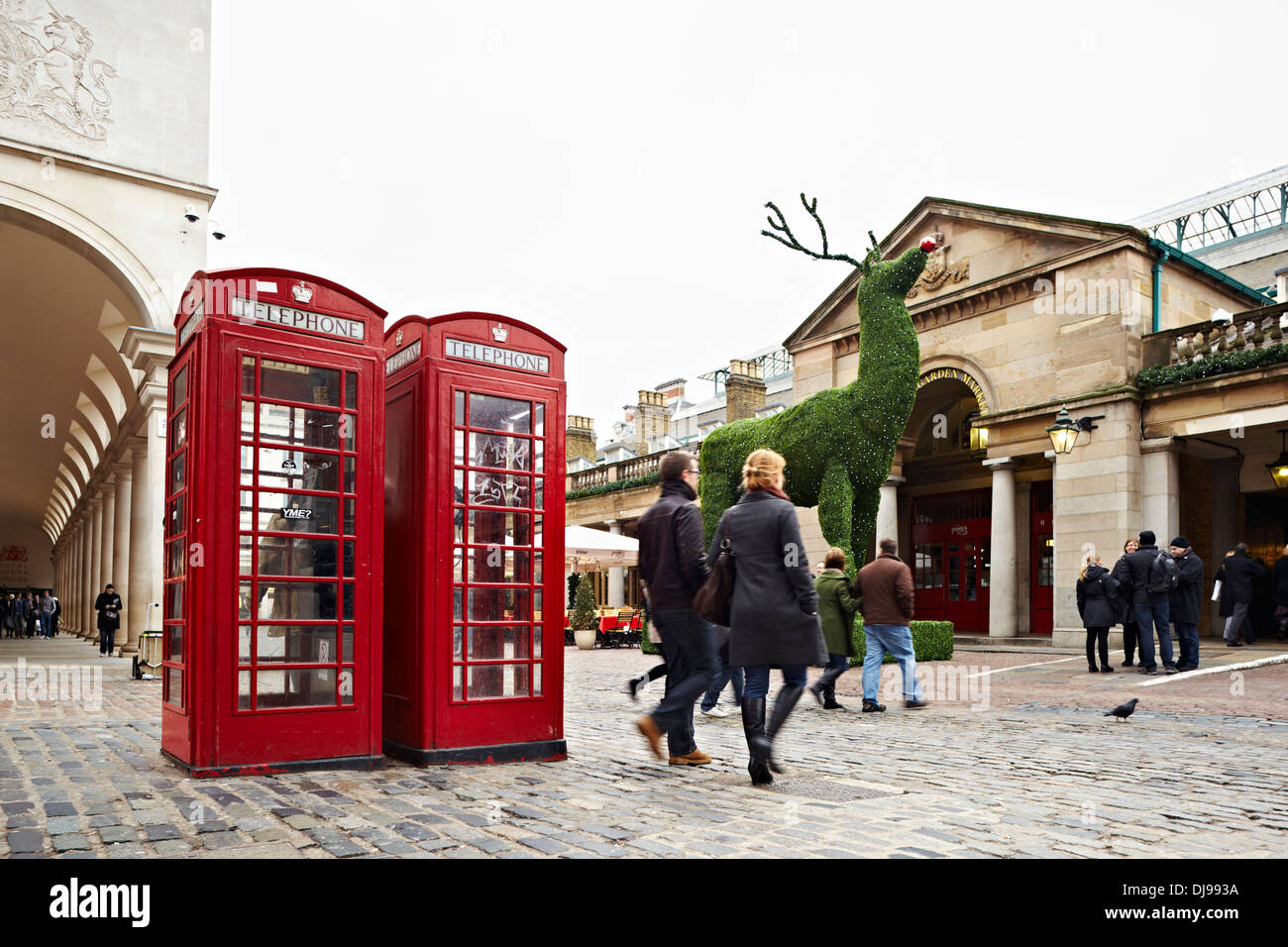 Red telephne boxe e gli acquirenti di Natale, Covent Garden, Londra, Inghilterra, Regno Unito Foto Stock