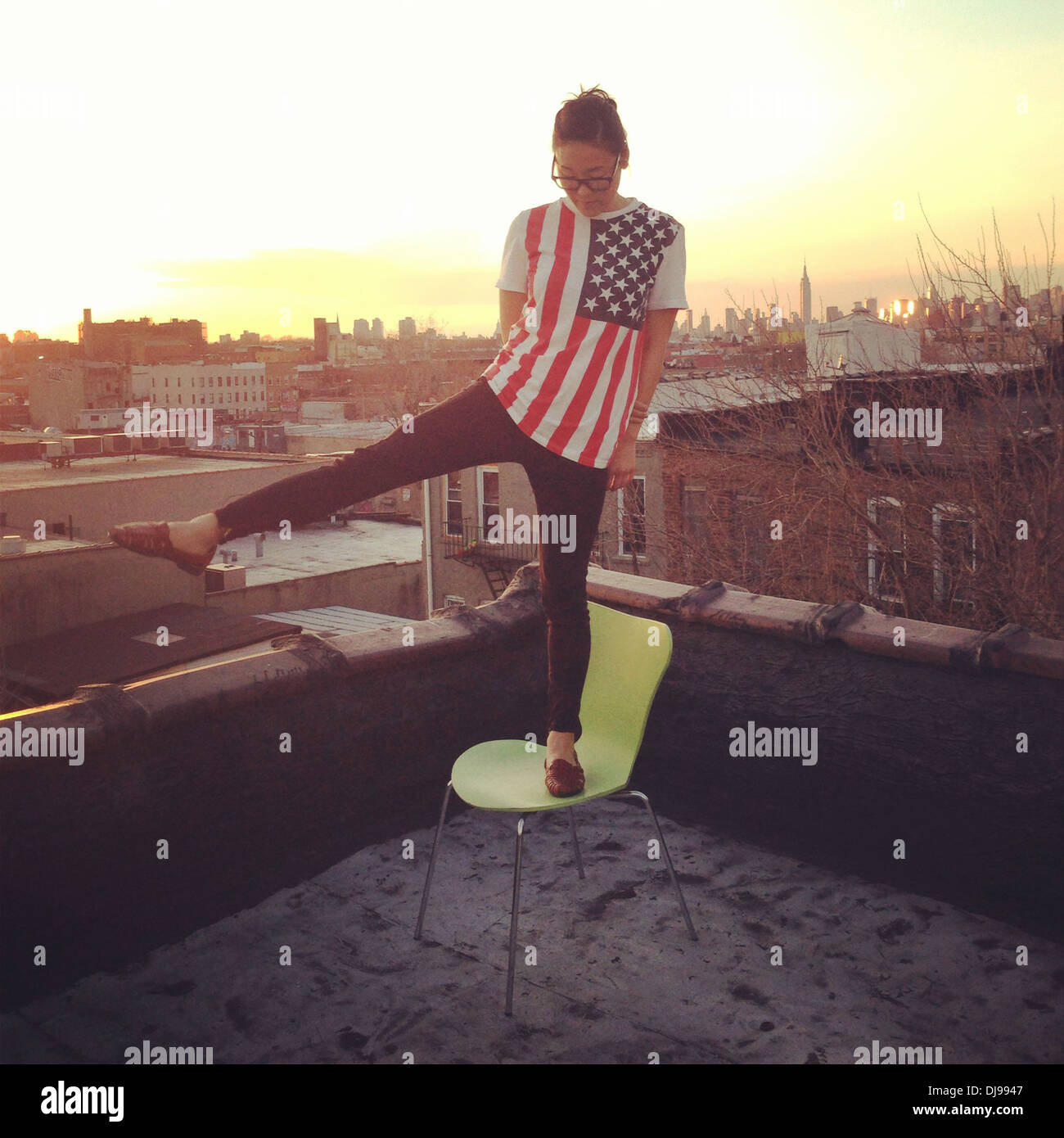 Donna che gioca sul tetto urbana, New York New York, Stati Uniti - Immagine stock catturata con smartphone