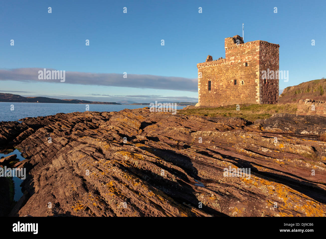 Il castello di Portencross, Ayrshire in Scozia, Regno Unito al tramonto con una vista verso nord lungo il Firth of Clyde Foto Stock
