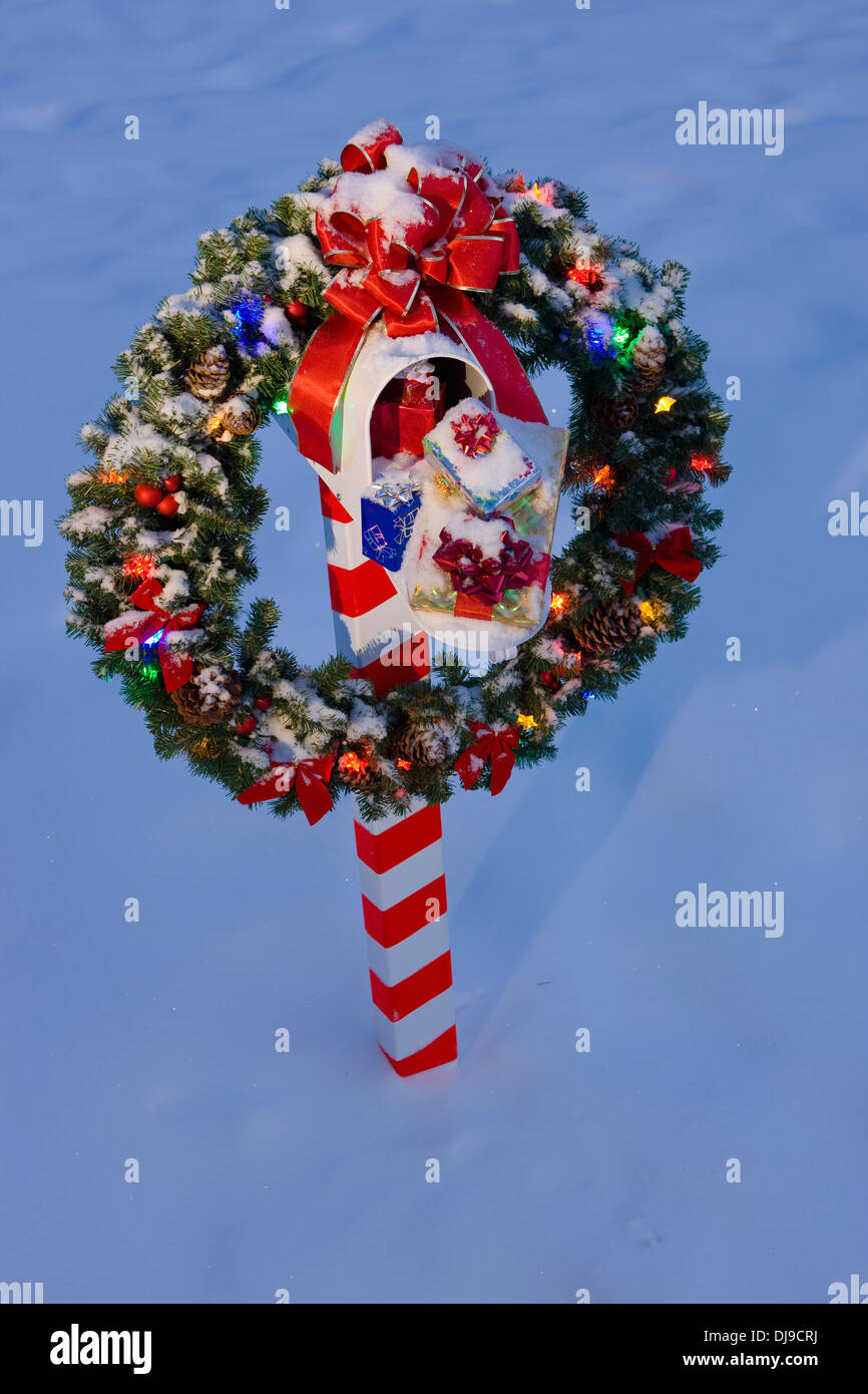 Mailbox decorato per il Natale, con corona e Candy Cane Striped Post in inverno vicino a Fairbanks Alaska Foto Stock