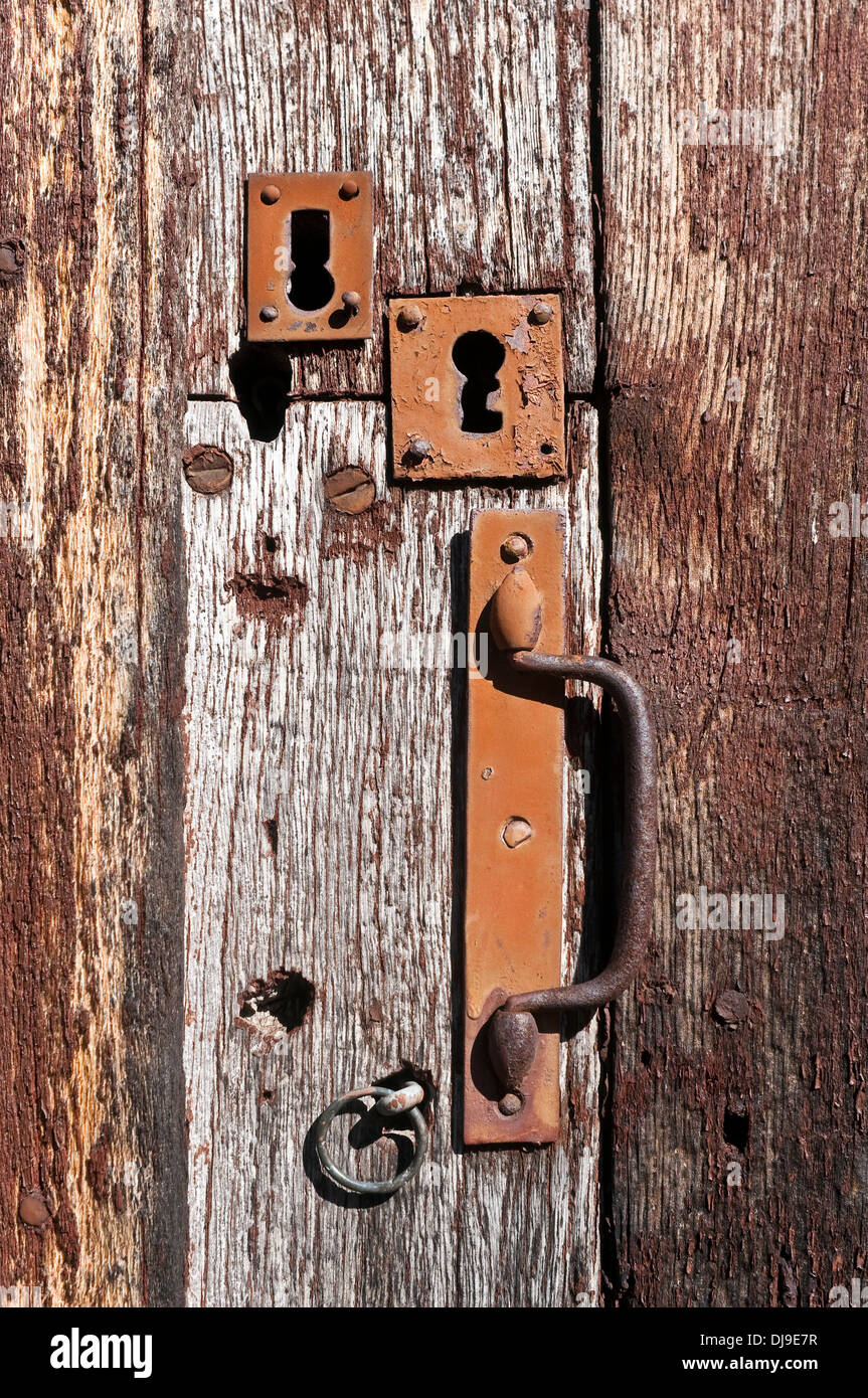 Vecchie piastre keyhole e maniglia su weathered porta in legno di quercia - Francia. Foto Stock
