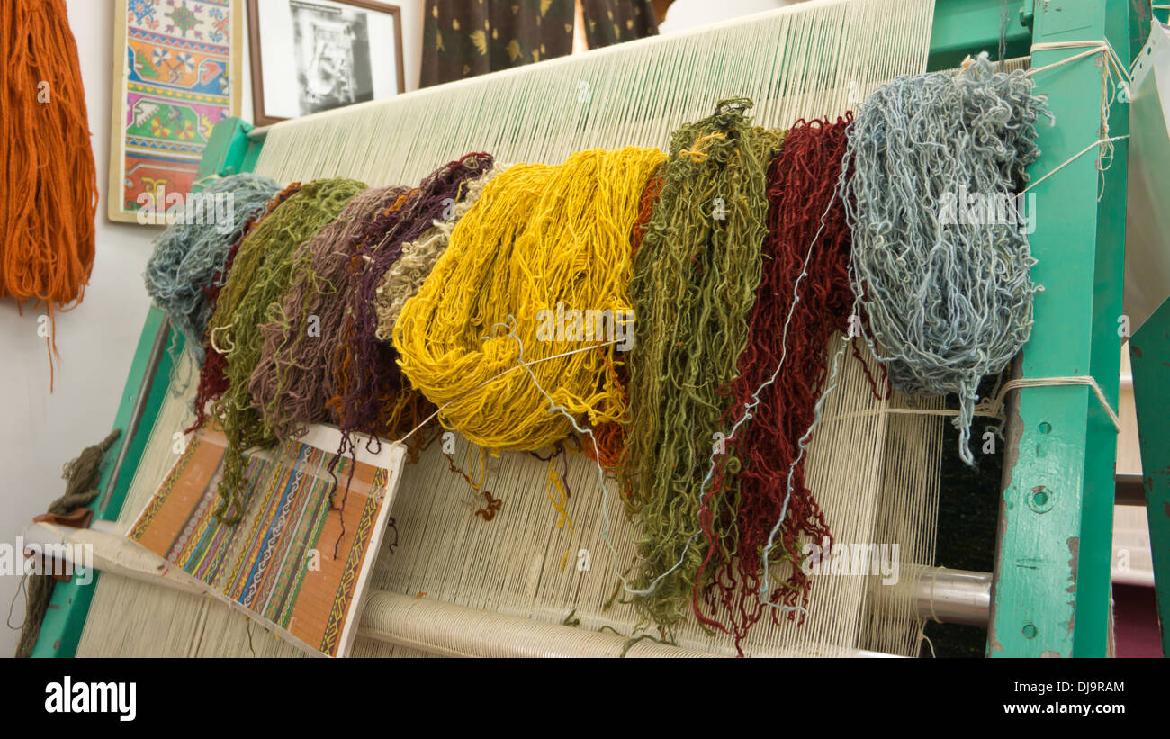 Matasse colorate di lana pronti per la fabbricazione di tappeti, su di un telaio di tessitura. Foto Stock