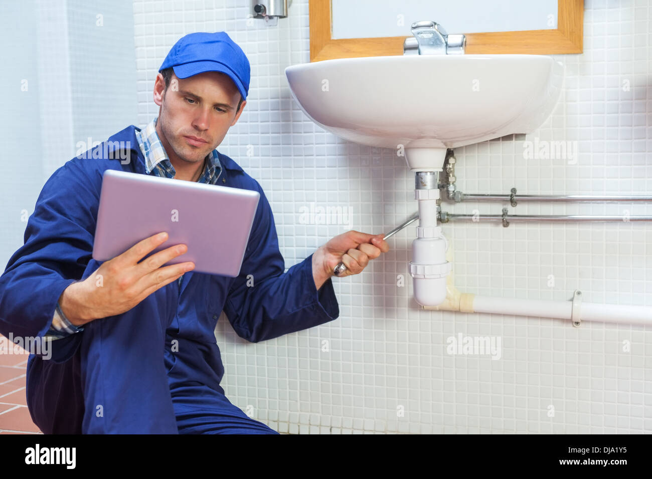 Grave plumber consulting tablet Foto Stock