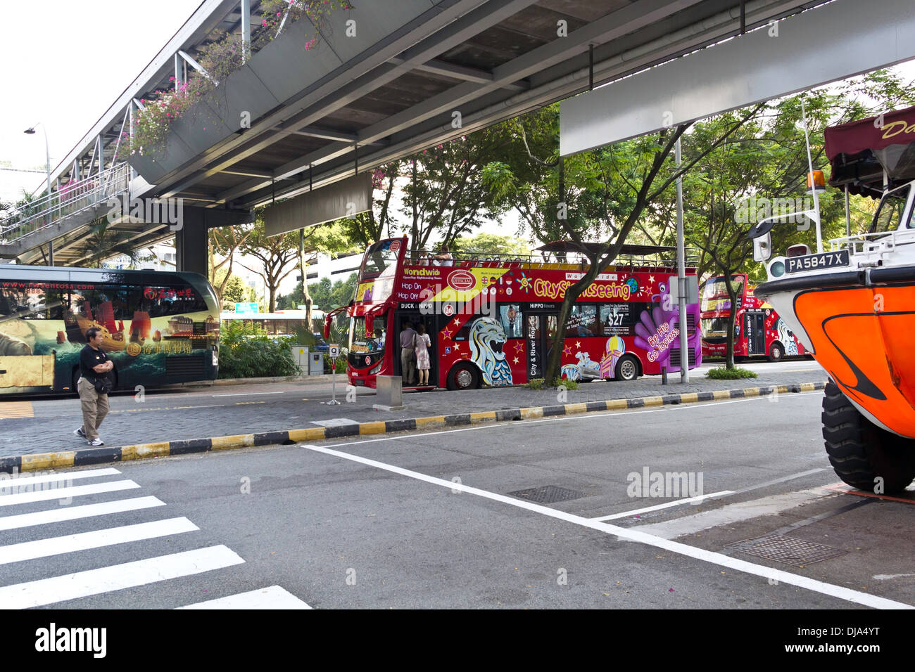 I bus turistici e veicolo anfibio utilizzato per diversi tour della città in Singapore, sotto un piede oltre-ponte in prossimità di Suntec City Foto Stock