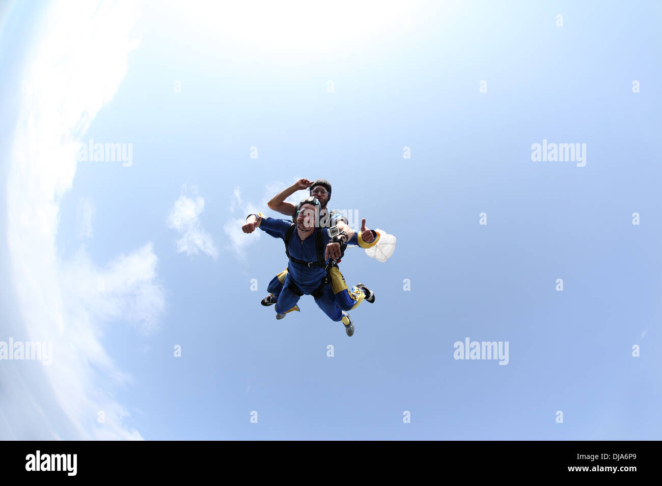 Paracadutista in tandem giovane si divertono insieme nel cielo. Il passeggero è di ammalarsi e il jump master è sorridente. Foto Stock