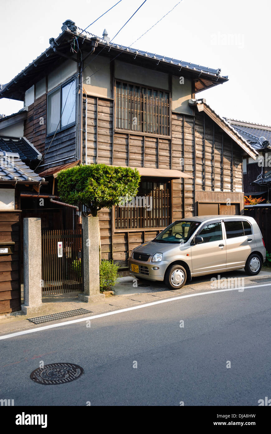 Compatta tradizionale giapponese home: casa in legno in Giappone con molto piccolo spazio parcheggio e topiaria da Foto Stock