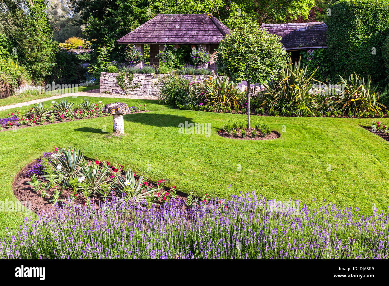 Il grazioso giardino paesaggistico di The Swan Hotel nel villaggio Costwold di Bibury in Coln Valley. Foto Stock