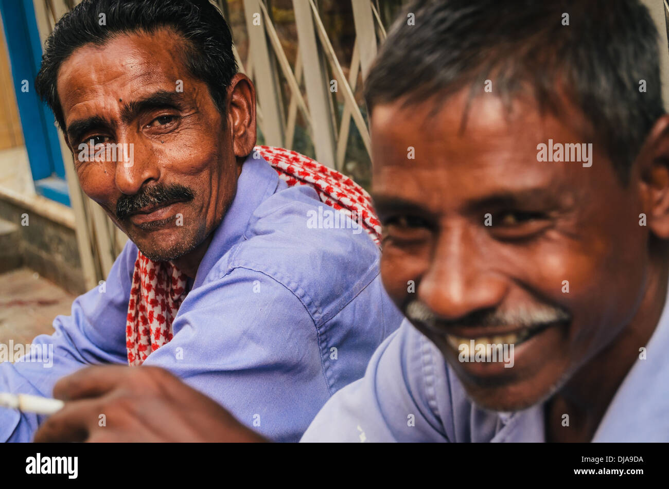 Due lavoratori immigrati si prendono una pausa dalle fatiche nelle strade di Deira. Dubai, Emirati Arabi Uniti. Foto Stock