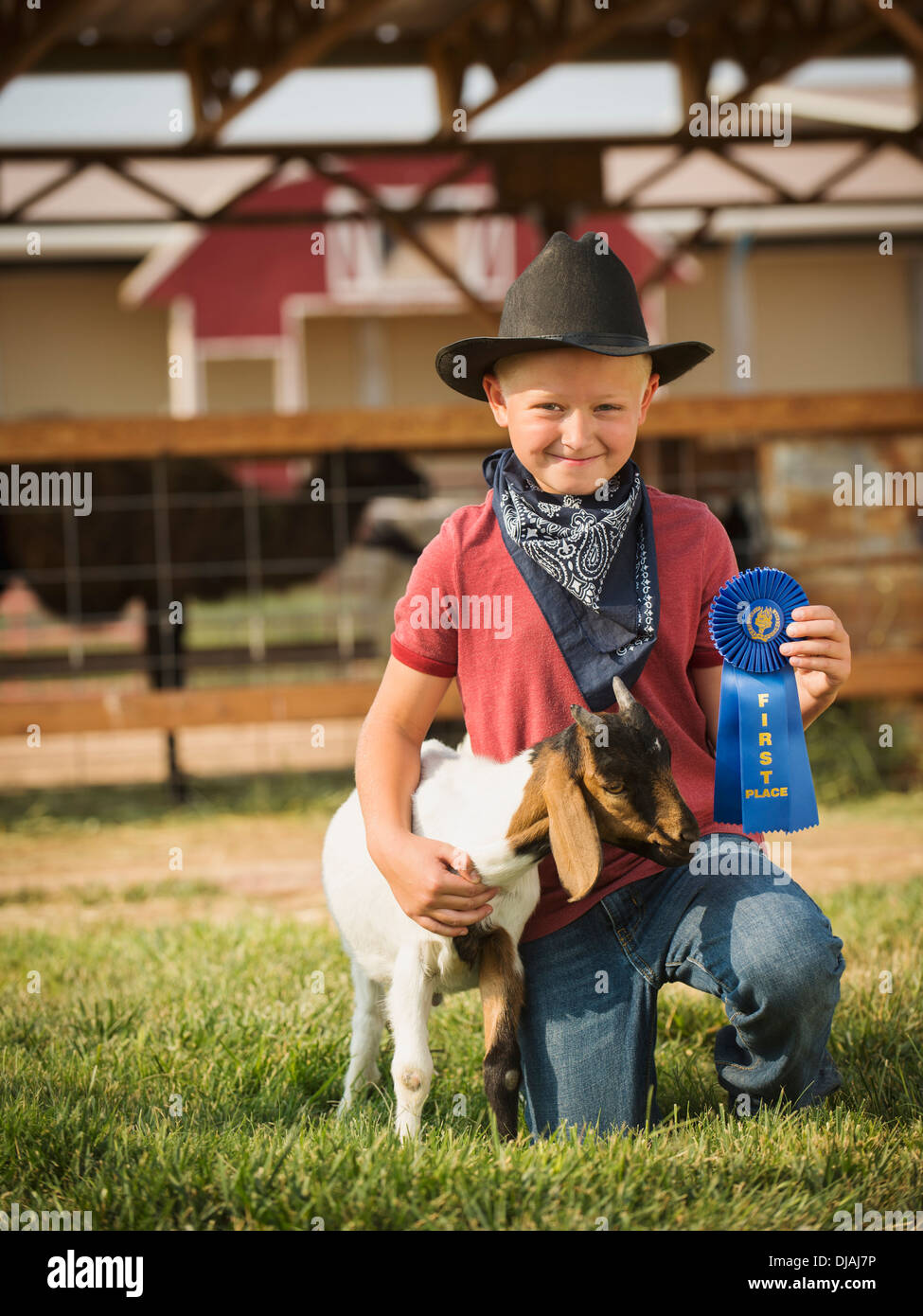 Ragazzo caucasico con il vincitore del premio per capra in agriturismo Foto Stock