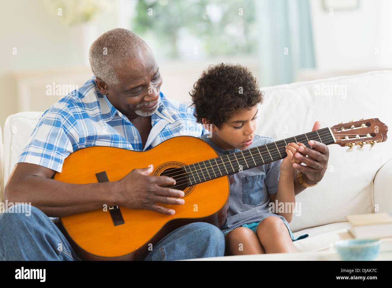 Ragazzo a suonare la chitarra con il nonno Foto Stock