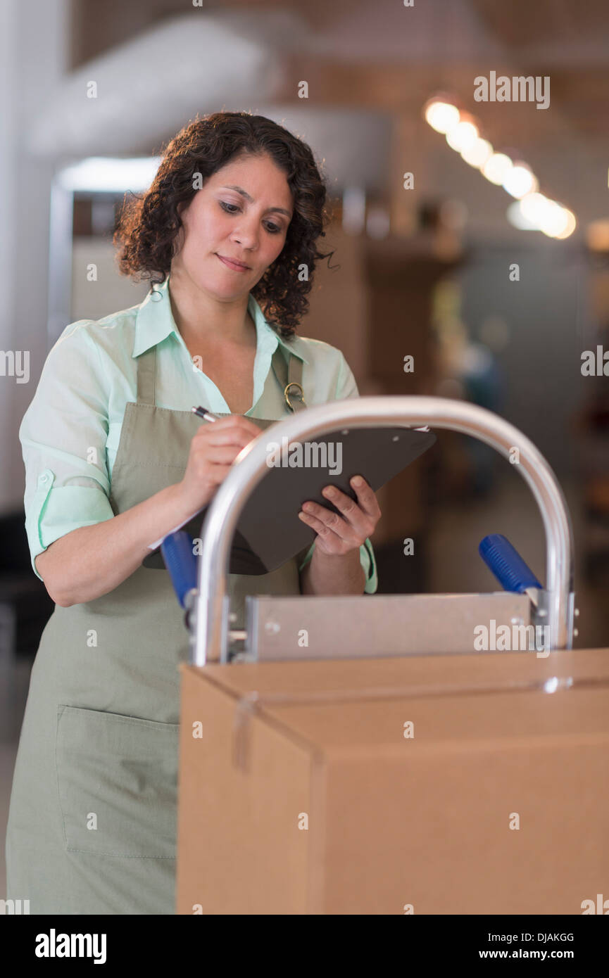 Donna ispanica lavorando in magazzino Foto Stock