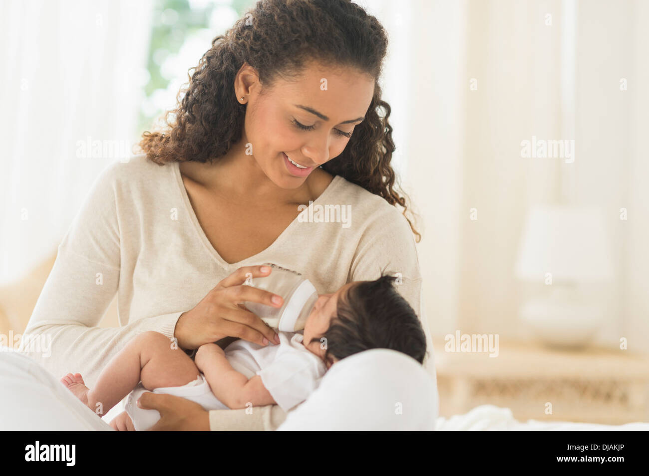 Madre ispanica alimentazione neonato Foto Stock