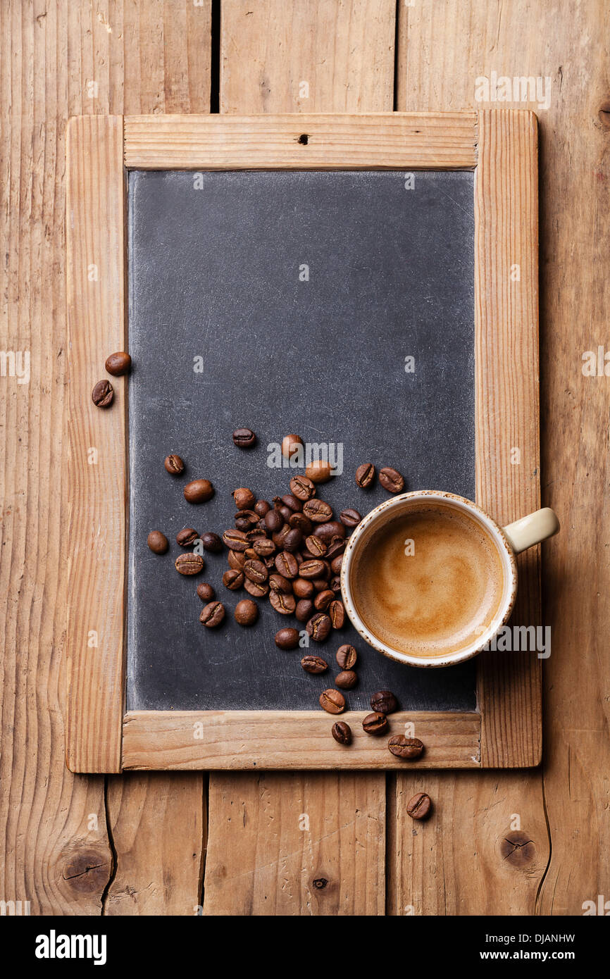 Tazza di caffè con i chicchi di caffè su ardesia vintage chalk board Foto Stock