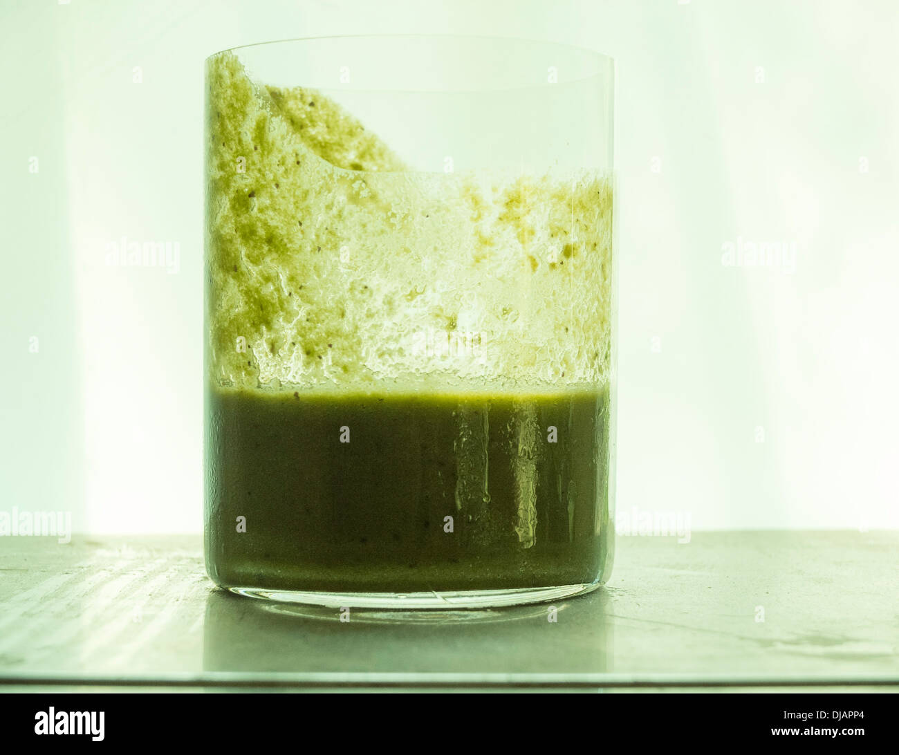 Mezza vuota bicchiere di succo verde Foto Stock