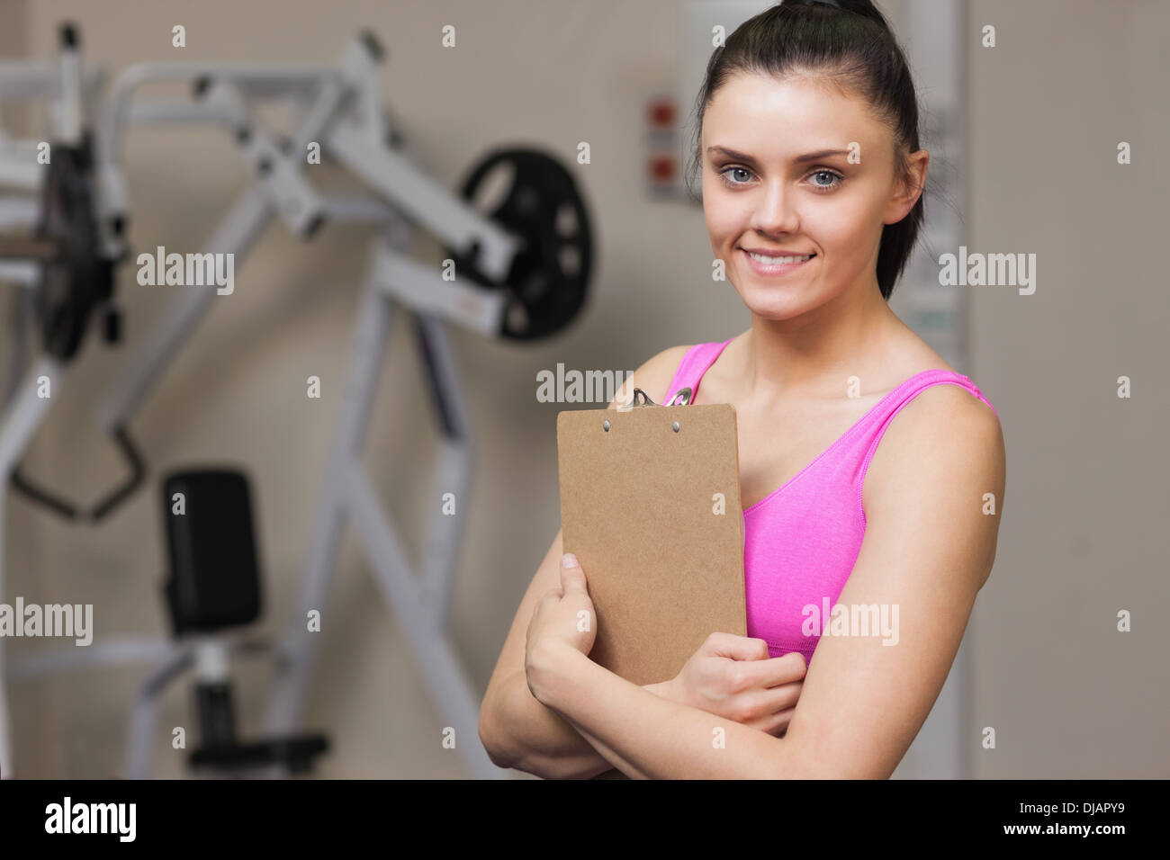 Donna sorridente con trainer appunti in palestra Foto Stock