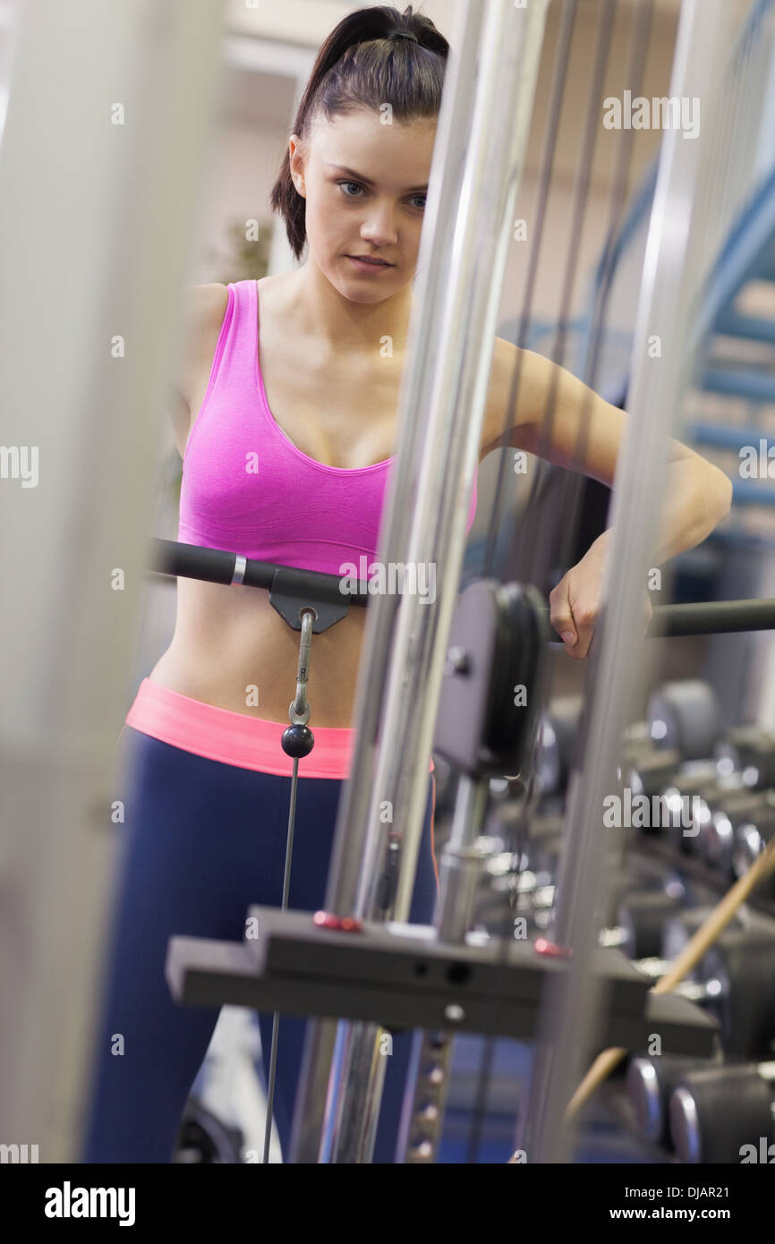Donna determinata a fare gli esercizi in palestra sul lat machine Foto Stock