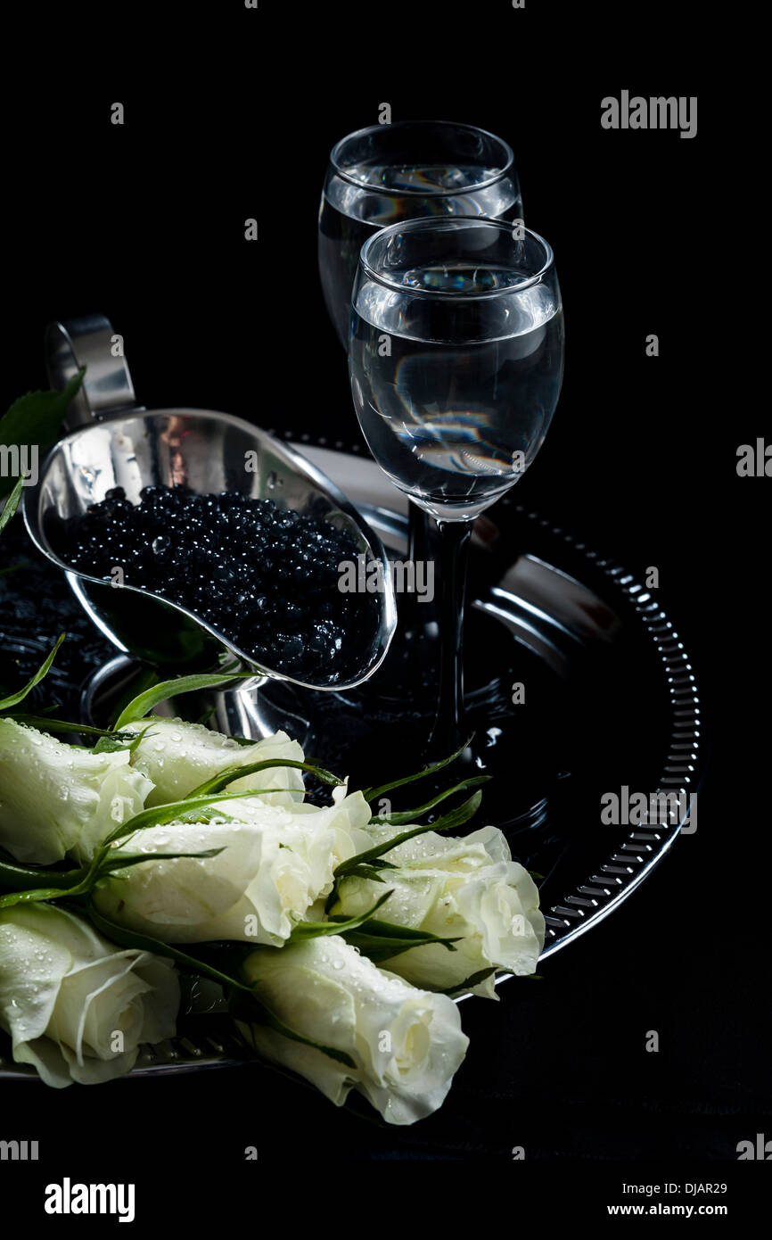 La vodka e il caviale nero su sfondo nero Foto Stock