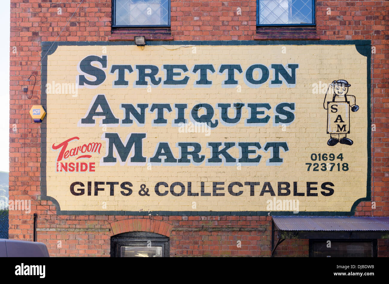 Grande segno per Stretton mercatino di Antiquariato verniciati esternamente la parete in mattoni di un edificio in Church Stretton nello Shropshire Foto Stock