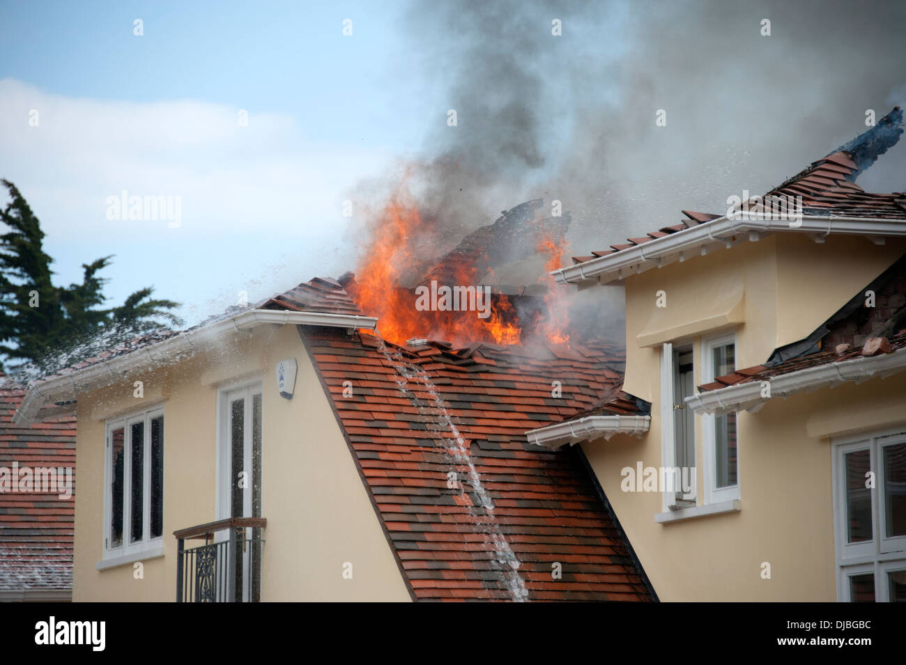 Sul tetto della casa sul fuoco Roofspace fiamme ben illuminato Foto Stock