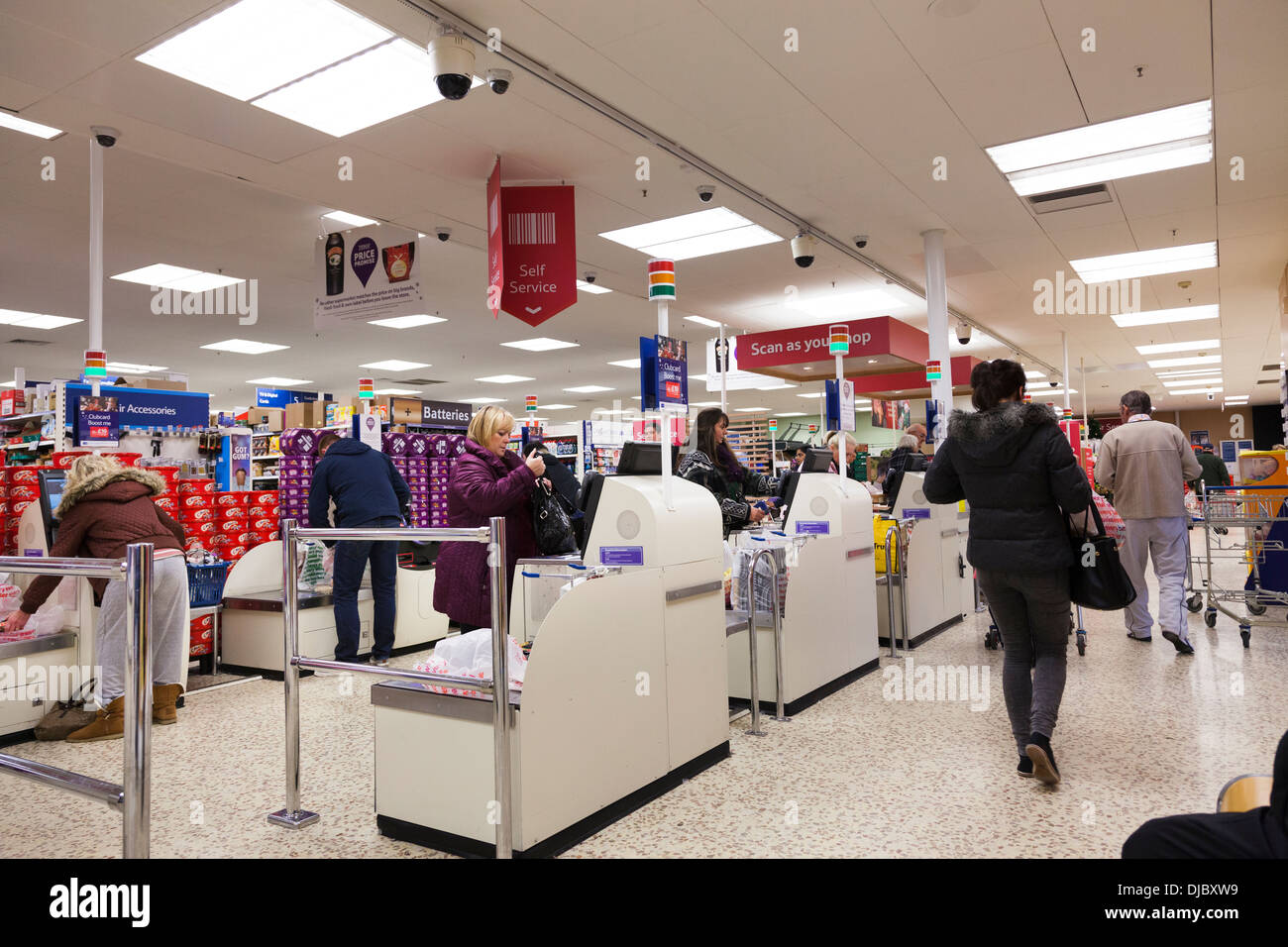I clienti che passa attraverso il self-service area check-out al supermercato Tesco. Foto Stock