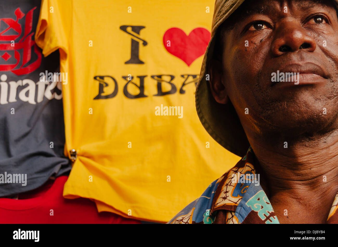 Un immigrato africano di vendita magliette souvenir a Bur Dubai Souk. Dubai, Emirati Arabi Uniti. Foto Stock