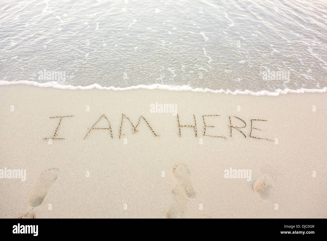 Il messaggio, io sono qui, scritto nella spiaggia di sabbia di St. Croix, U.S. Isole vergini per una felice turista. Foto Stock