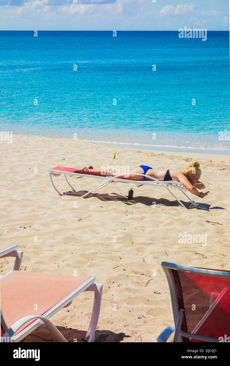 Una giovane donna caucasica in un bikini sunbathes sulla spiaggia di castelli di sabbia di St. Croix, Isole Vergini americane. Foto Stock