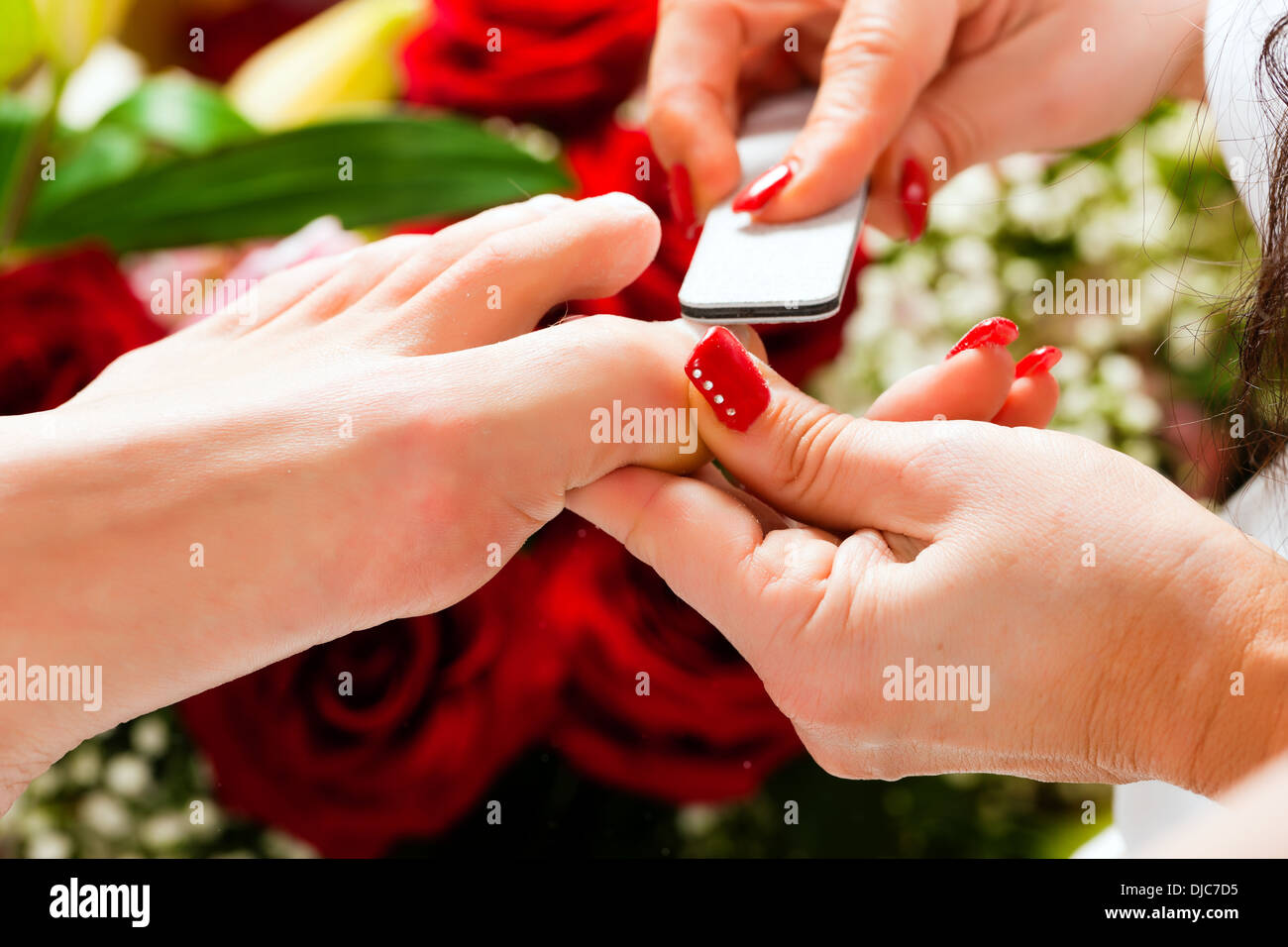 Donna pedicure ricevente in una Day Spa; un sacco di fiori in background Foto Stock